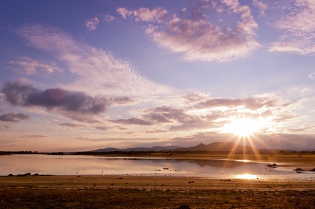 landscape of sunset on a lake with bright sunshine