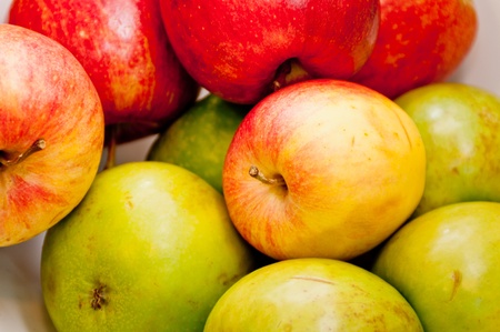 Apples of different colors and flavors stacked on each otherの写真素材