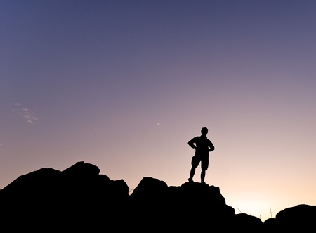 Man s silhouette in the high of a hill at the sunset - Horizontalの写真素材