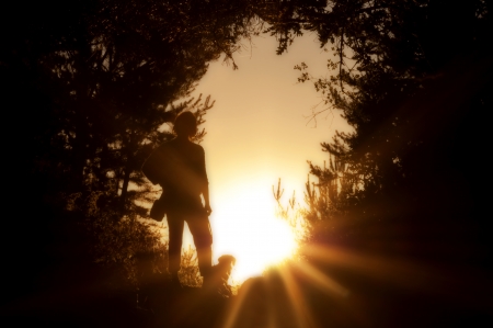 Woman and her pet pose at sunset in a natural frame - Horizontalの写真素材