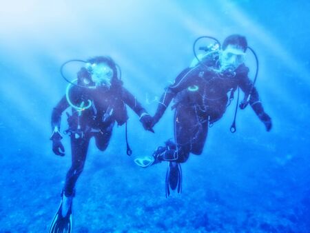 Couple enjoys scuba diving under the sea の写真素材
