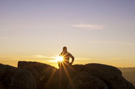 Man on top watching the sunset aloneの写真素材