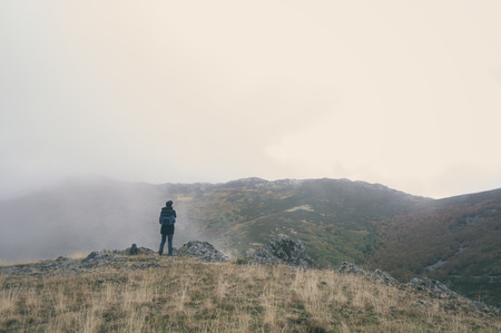 Woman hiking with your pet on a cloudy autumn day