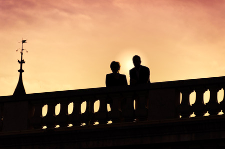 Silhouette of couple on the bridge at sunsetの写真素材