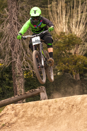Extreme jump on a bike in forest during competition downhillの写真素材