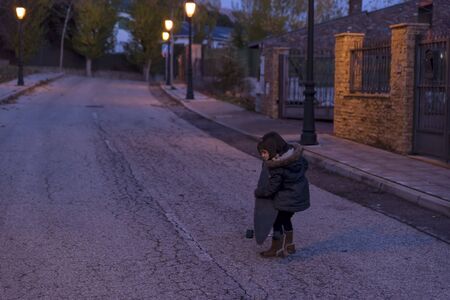 Girls playing with skateboard on the street at sunsetの写真素材