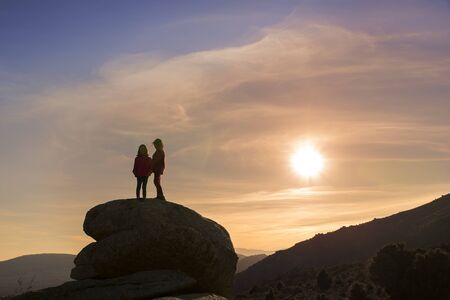 Girls playing at sunset on top of the mountainの写真素材
