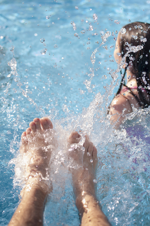 Playing to splash with the feet in the pool