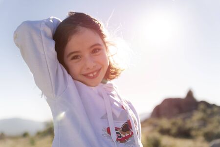 Little girl enjoys and plays in the sunlight on the hillの写真素材