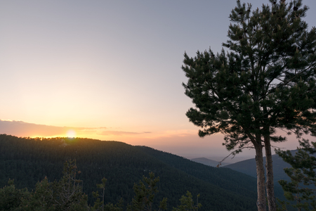 Beautiful sunrise in the morning clear sky with rays and mountain silhouetteの写真素材