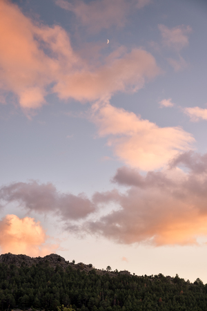 Colorful sunset with view or mountains and the moonの写真素材