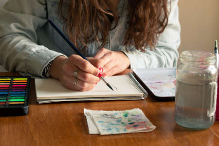 Lady's close-up shot starting a canvas using watercolor technique