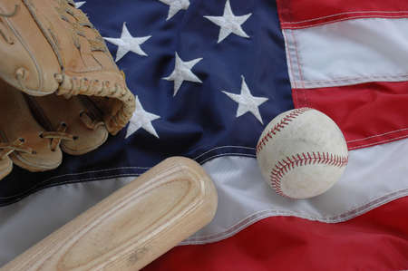 Baseball, bat and glove with American flag in the backgroundの写真素材