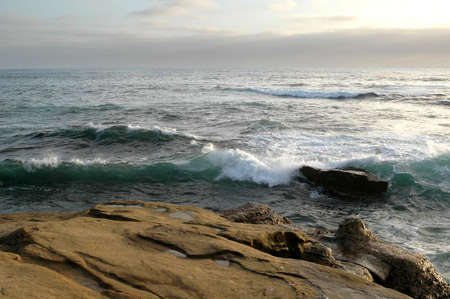 Rocks at Shore San Diego California Beach wit sun setting downの写真素材
