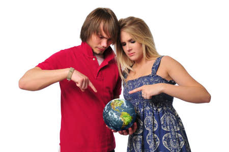 Young couple ponting to the earth isolated on whiteの写真素材