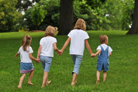 Children holding hands and walking outdoorsの写真素材