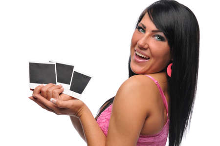 Young brunette holding snapshots and smiling isolated on whiteの写真素材
