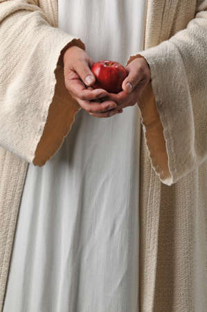 Jesus's hands holding an apple as a symbol of producing fruitの写真素材