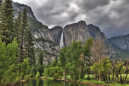 Yosemite view from the river with water fall an cloudy sky