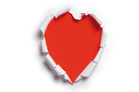 Ripped paper in the shape of a heart against a red backgroundの写真素材