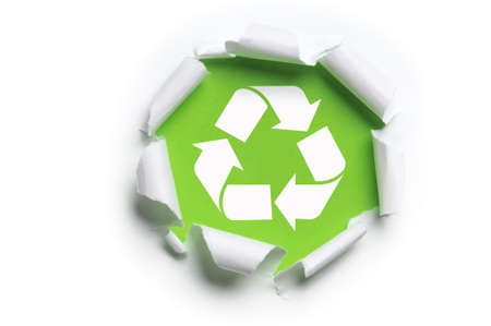 ripped white paper with recycle logo against a green backgroundの写真素材