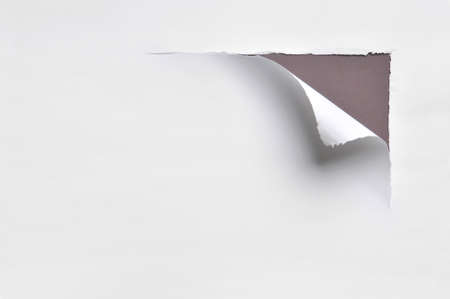 ripped white paper against a brown backgroundの写真素材