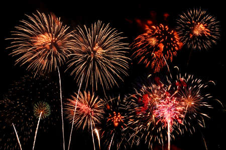 Fireworks of multiple colors bursting against a black background