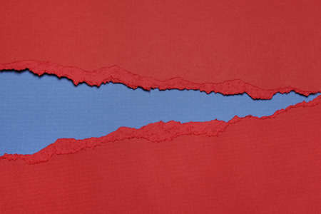 Rip red Paper and blue bakground with space for textの写真素材