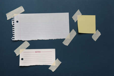 Notes with masking tape on a green boardの写真素材