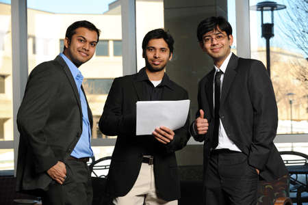 Group of Businessmen standing up inside an office buildingの写真素材
