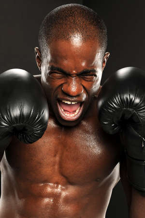 Young African American Boxer screaming isolated on a dark background