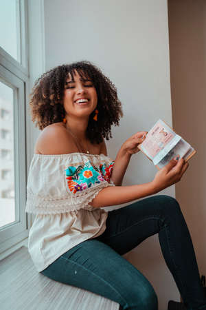woman smiling while she is reading a book