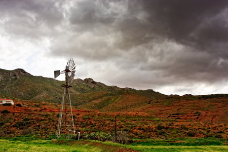 hilly landscape with windmill for water extraction
