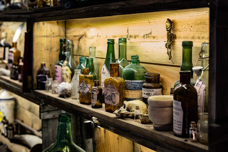 Vintage bottles and glass jars on a shelf in a wine cellar
