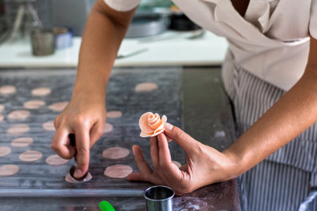 Close-up of confectioner's hands making pastries at pastry shop