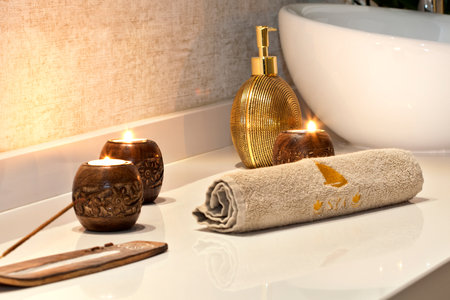 Spa and wellness setting with candles and towels in bathroom interior.