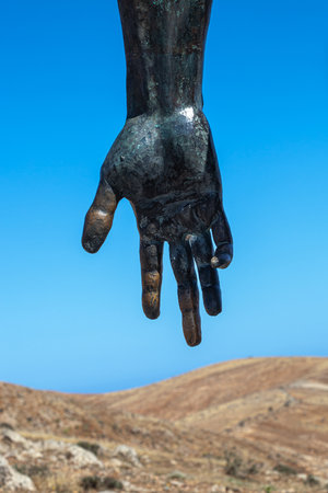 sculpture of the hands of a zombie on a background of blue skyの写真素材