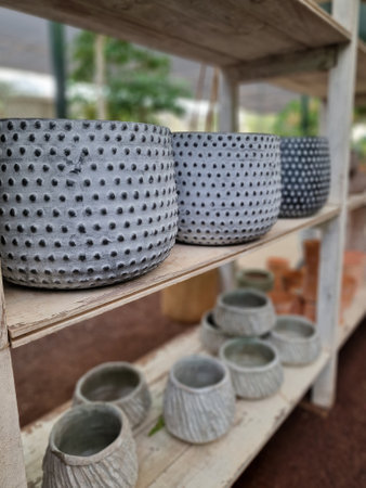Ceramic pottery on wooden shelf in the garden, stock photo