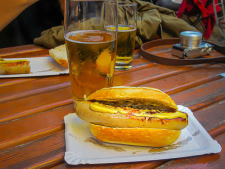 Delicious hot dog with lots of mustard, served with ice-cream chopps, at happy hour, after taking photographs around the city.の写真素材