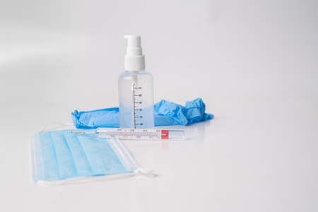 surgical mask with gloves thermometer and disinfectant gel white backgroundの写真素材