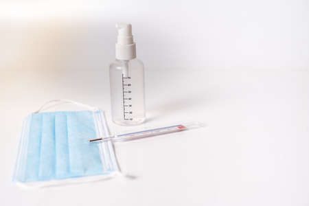 surgical mask with thermometer and disinfectant gel white background