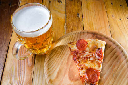 Slice of traditional  pepperoni pizza and beerの写真素材