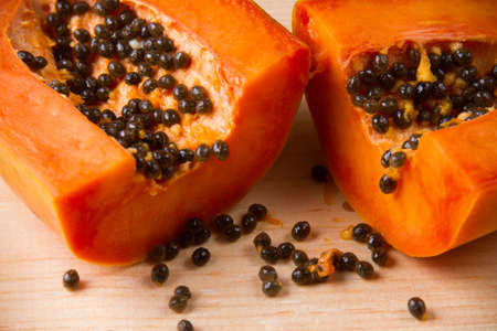 Ripe papaya fruit half on wood tableの写真素材