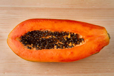 Ripe papaya fruit half on wood tableの写真素材