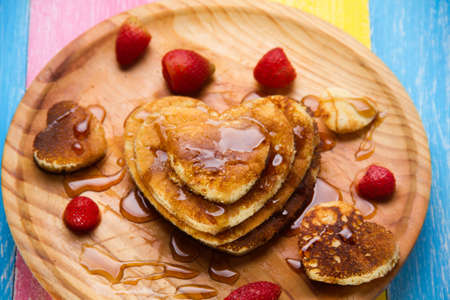 Hot heart pancake with strawberry and maple syrup