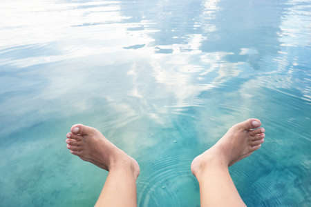 Woman feets into the waterの写真素材