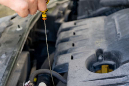 Man hand checking oil level in carの写真素材