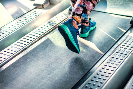 Young woman running on gym machine