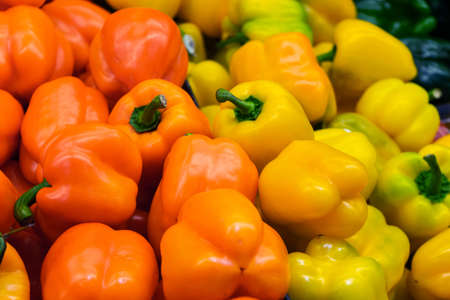 Orange and yellow peppers in marketの写真素材