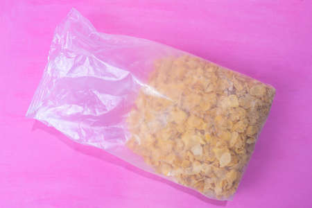Corn flakes cereal breakfast in plastic bag on colorful background